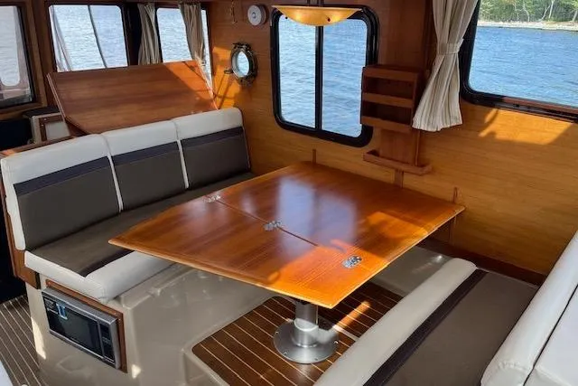 Mystic Yacht Photos Pics 2014 Ranger Tugs R-31 interior with wooden dining table and cushioned seating.