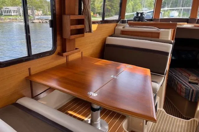 Mystic Yacht Photos Pics 2014 Ranger Tugs R-31 interior with wooden table and seating, overlooking water.