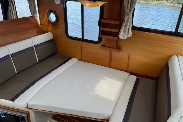 Mystic Yacht Photos Pics Cozy interior of 2014 Ranger Tugs R-31 with convertible seating and scenic water view.