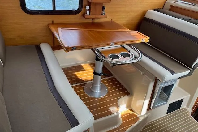 Mystic Yacht Photos Pics Interior of 2014 Ranger Tugs R-31 with wooden table and cushioned seating.