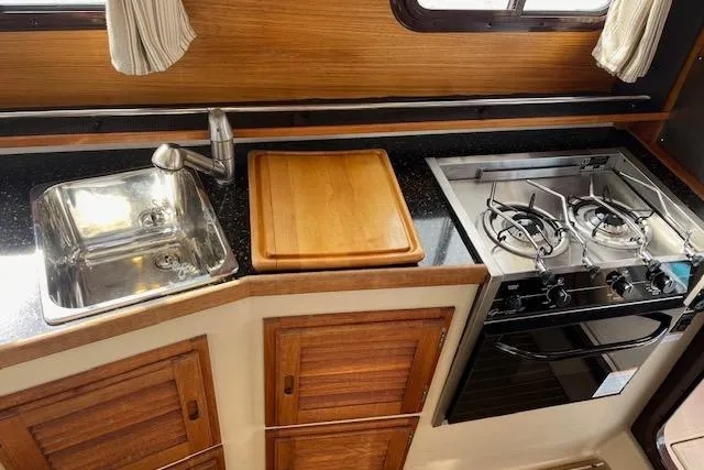 Mystic Yacht Photos Pics 2014 Ranger Tugs R-31 galley with sink, stove, and wooden cabinetry.