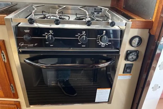 Mystic Yacht Photos Pics 2014 Ranger Tugs R-31 kitchen stove and oven with control knobs and wooden cabinetry.