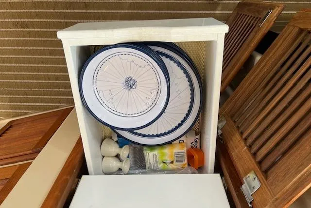 Mystic Yacht Photos Pics Storage compartment in a 2014 Ranger Tugs R-31 with plates and kitchen items.