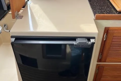 Mystic Yacht Photos Pics 2014 Ranger Tugs R-31 interior with compact refrigerator and wooden cabinetry.