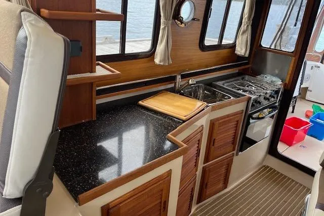 Mystic Yacht Photos Pics Interior of 2014 Ranger Tugs R-31 boat with kitchen and wooden cabinetry.