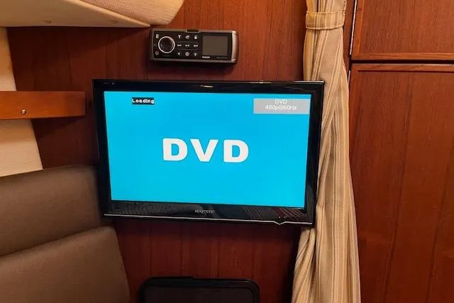 Mystic Yacht Photos Pics DVD player setup inside 2014 Ranger Tugs R-31 boat cabin with wood paneling.
