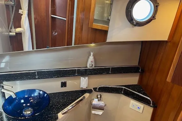 Mystic Yacht Photos Pics 2014 Ranger Tugs R-31 bathroom with blue sink, porthole, and wooden accents.
