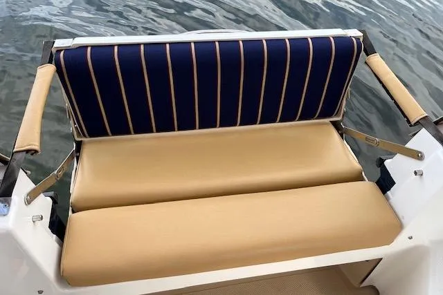 Mystic Yacht Photos Pics 2014 Ranger Tugs R-31 boat seat with striped backrest, beige cushions, and water backdrop.