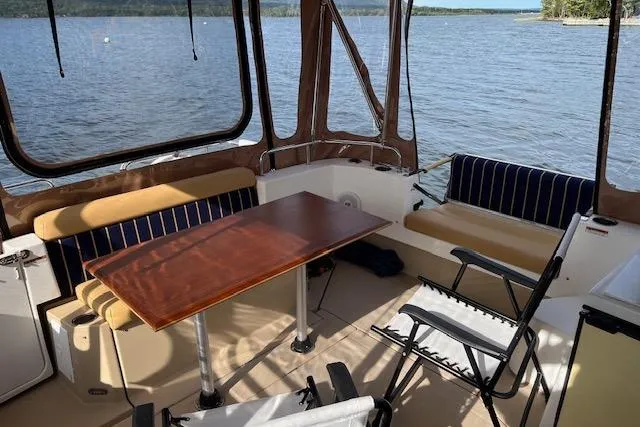 Mystic Yacht Photos Pics 2014 Ranger Tugs R-31 boat interior with seating and table, overlooking serene water.