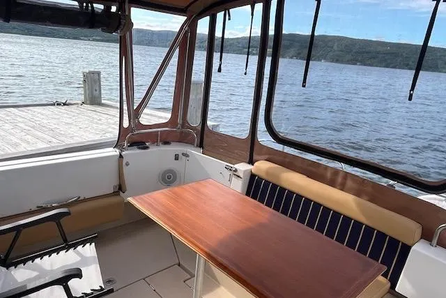 Mystic Yacht Photos Pics 2014 Ranger Tugs R-31 boat interior with wooden table, docked by a scenic lake.