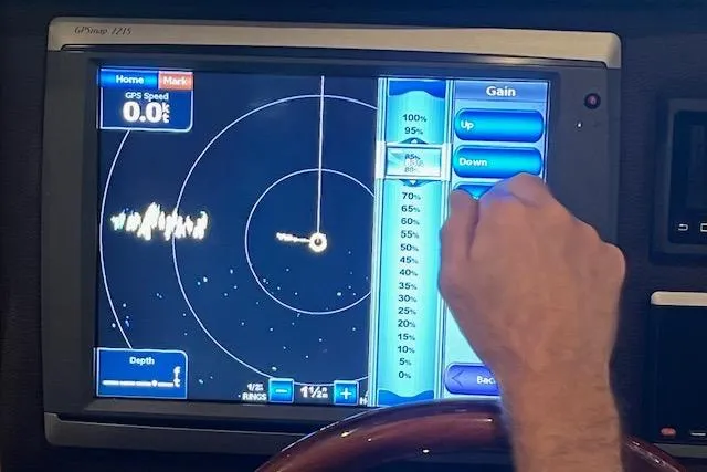 Mystic Yacht Photos Pics Hand adjusting radar settings on a Ranger Tugs R-31 boat's navigation display, 2014 model.