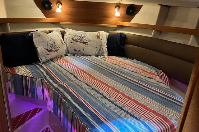 Mystic Yacht Photos Pics Cozy cabin interior of 2014 Ranger Tugs R-31 with nautical-themed bedding and ambient lighting.
