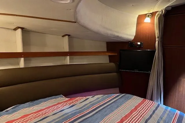 Mystic Yacht Photos Pics Cozy interior cabin of 2014 Ranger Tugs R-31 with striped bedding and wall-mounted TV.