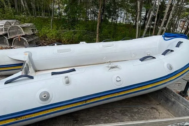 Mystic Yacht Photos Pics Inflatable boat on trailer, surrounded by trees and lobster traps. Ranger Tugs R-31, 2014 model.