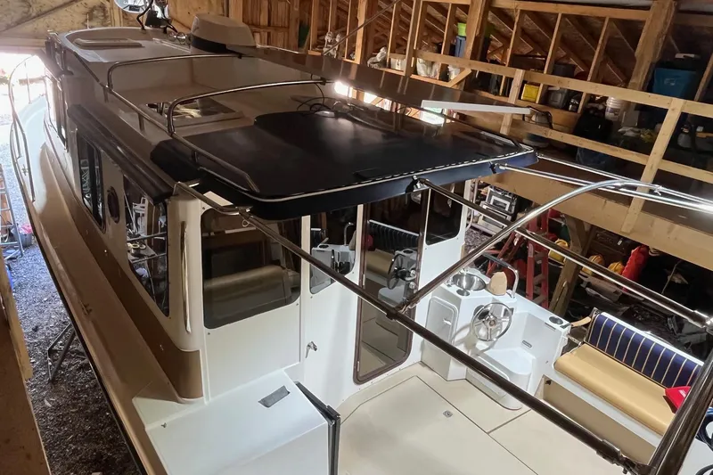Mystic Yacht Photos Pics 2014 Ranger Tugs R-31 boat in a wooden garage, showcasing deck and seating area.