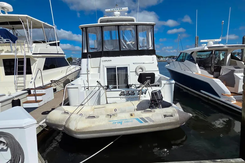 All In Yacht Photos Pics 2004 Carver 444 Cockpit Motor Yacht docked with inflatable boat, clear sky background.