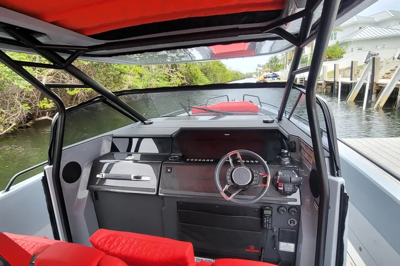  Yacht Photos Pics 2022 Axopar Brabus Shadow 900 ST boat interior with red seating and modern dashboard.