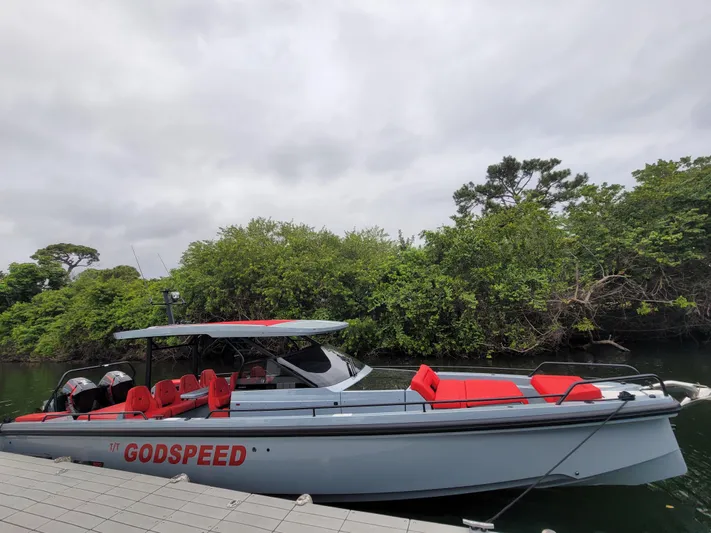  Yacht Photos Pics 2022 Axopar Brabus Shadow 900 ST boat docked near lush greenery.