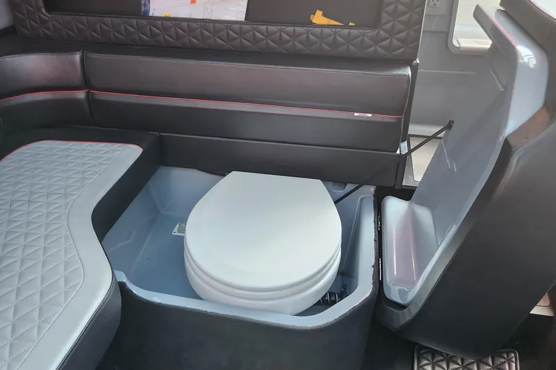  Yacht Photos Pics 2022 Axopar Brabus Shadow 900 ST interior with a compact marine toilet.