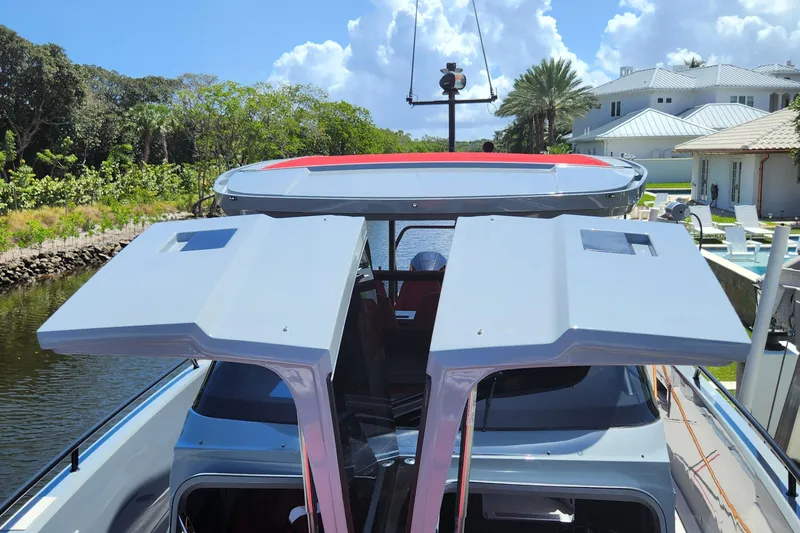  Yacht Photos Pics 2022 Axopar Brabus Shadow 900 ST with open roof hatches, docked near luxury homes.