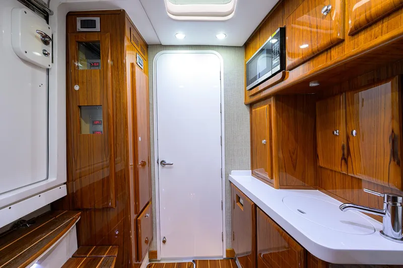  Yacht Photos Pics Luxurious 2021 HCB 53 Sueños yacht interior with wood cabinetry and modern amenities.