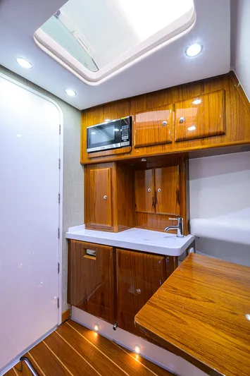  Yacht Photos Pics Luxurious 2021 HCB 53 Sueños yacht interior with wood cabinetry and modern amenities.