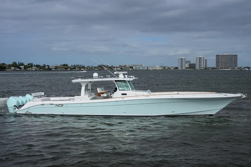  Yacht Photos Pics 2021 HCB 53 Sueños boat on calm water with cityscape background.