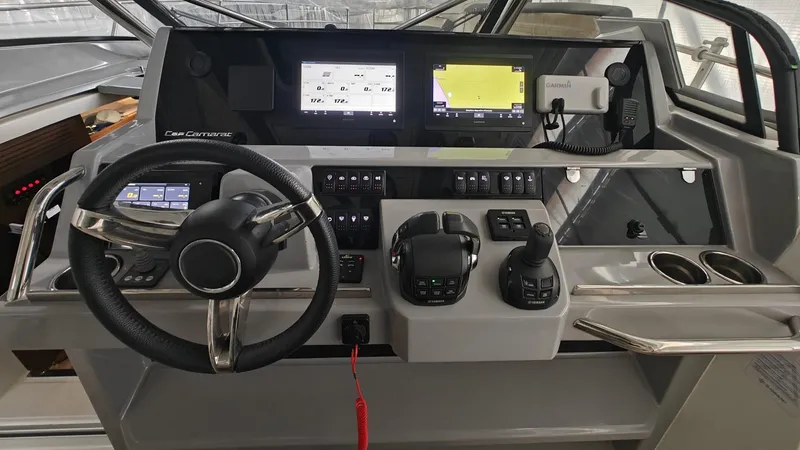 Yacht Photos Pics Cockpit of 2021 Jeanneau CAP CAMARAT 12.5WA with modern navigation controls and steering wheel.