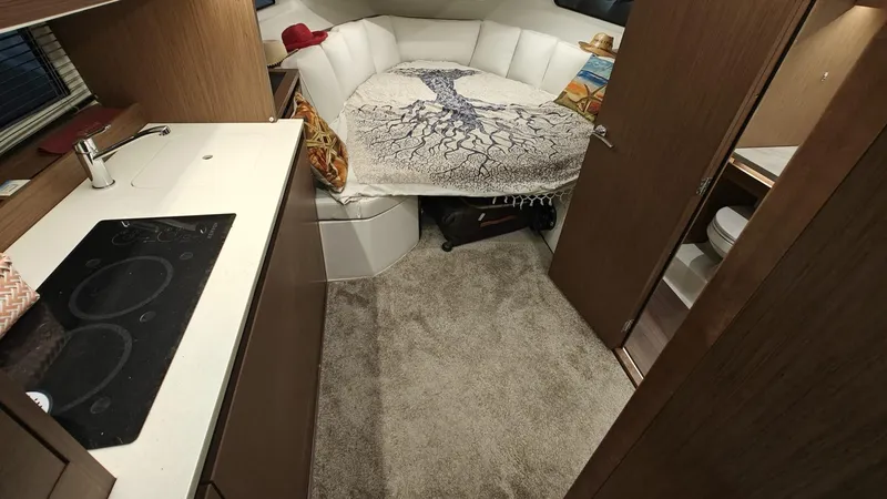  Yacht Photos Pics Interior of 2021 Jeanneau CAP CAMARAT 12.5WA with cozy bed and kitchenette.