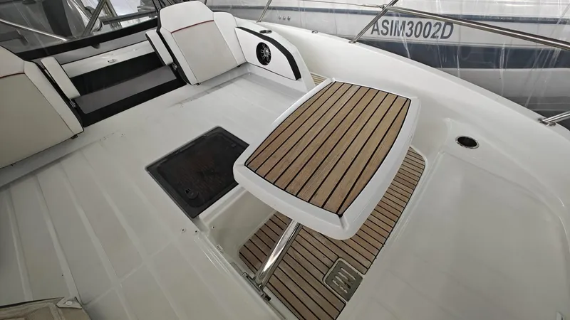  Yacht Photos Pics 2021 Jeanneau CAP CAMARAT 12.5WA boat interior with sleek wooden table and seating.