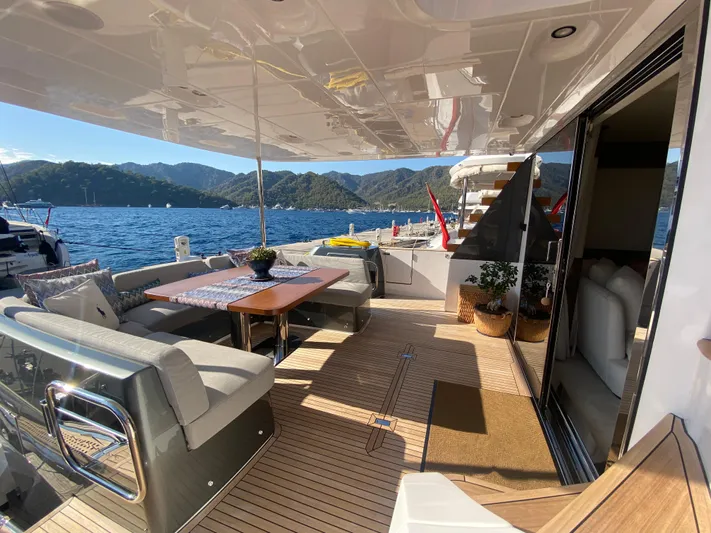  Yacht Photos Pics Luxurious 2025 Azimut Magellano 66 yacht deck with elegant seating and scenic ocean view.