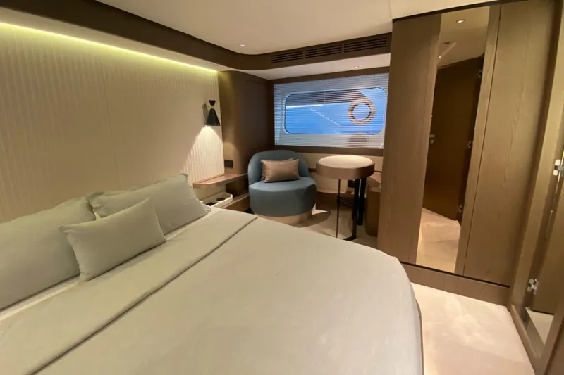  Yacht Photos Pics Luxurious bedroom interior of 2025 Azimut Magellano 66 yacht, featuring modern design and cozy seating.