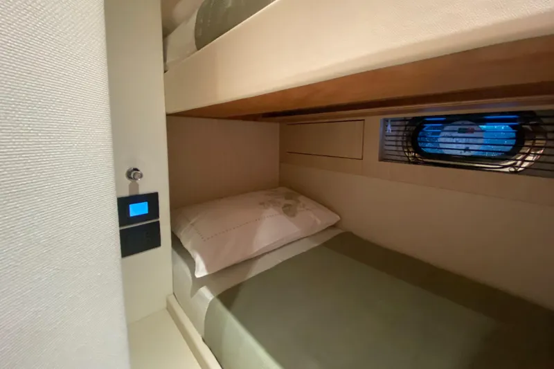  Yacht Photos Pics Cozy cabin interior of 2025 Azimut Magellano 66 yacht with bunk bed and window.