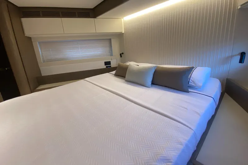  Yacht Photos Pics Luxurious bedroom interior of 2025 Azimut Magellano 66 yacht, featuring a comfortable bed and modern design.
