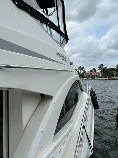  Yacht Photos Pics 2009 Sea Ray 36 Sedan Bridge yacht docked by waterfront homes under cloudy skies.