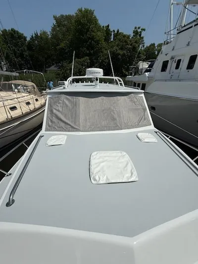 Outcast Yacht Photos Pics 2004 Mabry 40 boat docked among other vessels, featuring a sleek design and covered windows.