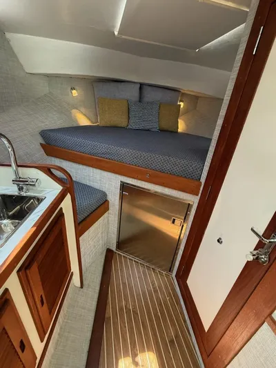 Outcast Yacht Photos Pics Cozy cabin interior of 2004 Mabry 40 boat with bed, sink, and wooden accents.