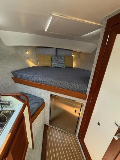 Outcast Yacht Photos Pics Interior of 2004 Mabry 40 boat with cozy bed, kitchenette, and wooden accents.