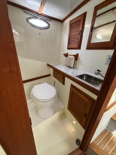Outcast Yacht Photos Pics Compact bathroom in 2004 Mabry 40 boat with wooden accents and porthole window.