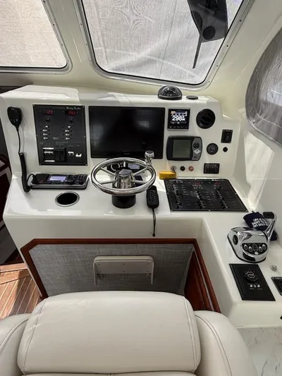Outcast Yacht Photos Pics Control panel of a 2004 Mabry 40 boat with steering wheel and navigation instruments.