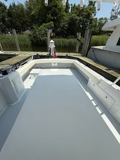 Outcast Yacht Photos Pics 2004 Mabry 40 boat deck at a dock, surrounded by greenery.