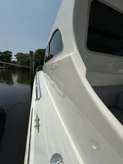 Outcast Yacht Photos Pics Side view of a 2004 Mabry 40 boat docked by a calm river.