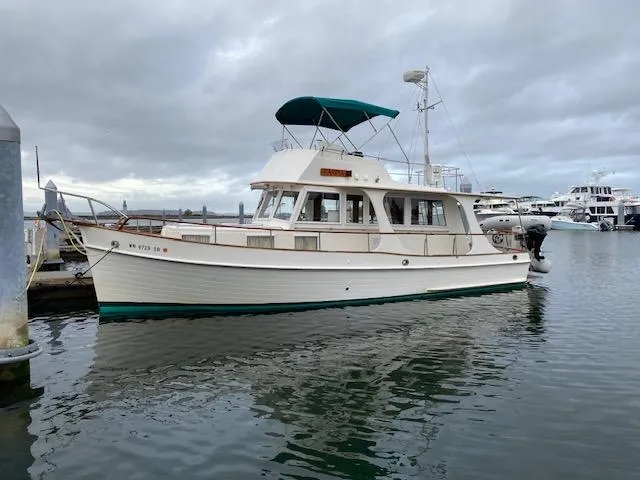  Yacht Photos Pics 1990 Grand Banks 36 Europa yacht docked in a marina under cloudy skies.