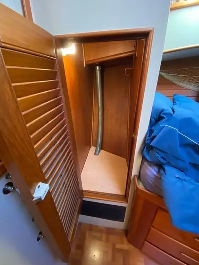  Yacht Photos Pics 1990 Grand Banks 36 Europa interior closet with wooden finish and ventilation pipe.