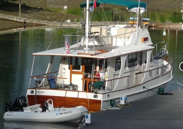  Yacht Photos Pics 1990 Grand Banks 36 Europa yacht docked with small dinghy attached.