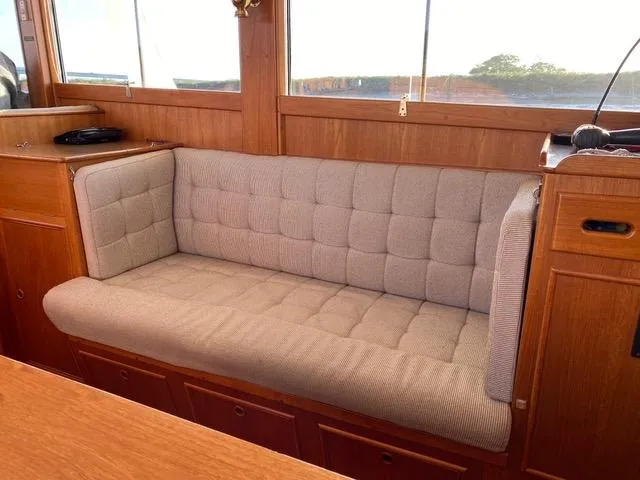  Yacht Photos Pics Interior of 1990 Grand Banks 36 Europa with cushioned seating and wooden paneling.