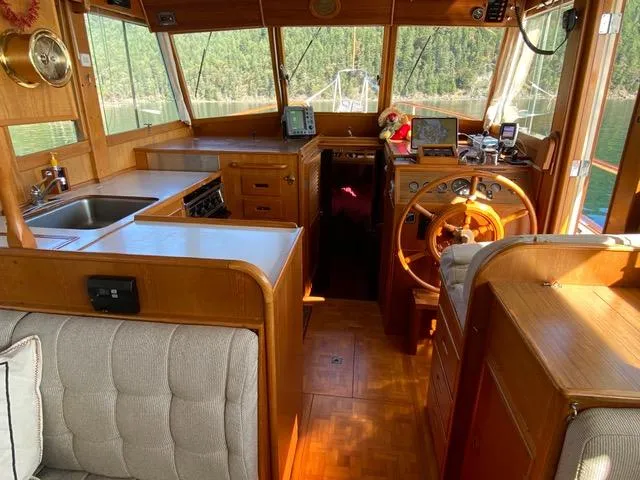  Yacht Photos Pics Interior of 1990 Grand Banks 36 Europa yacht with wooden helm and cozy seating.