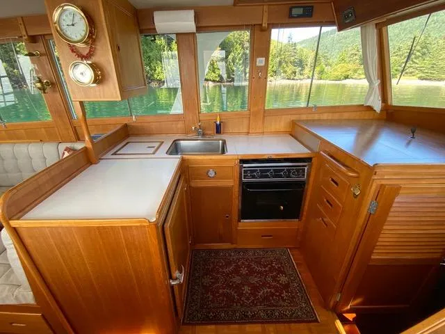  Yacht Photos Pics Interior of 1990 Grand Banks 36 Europa yacht kitchen with wood cabinetry and scenic window views.