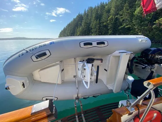  Yacht Photos Pics Inflatable boat on Grand Banks 36 Europa, 1990, docked by forested shoreline.