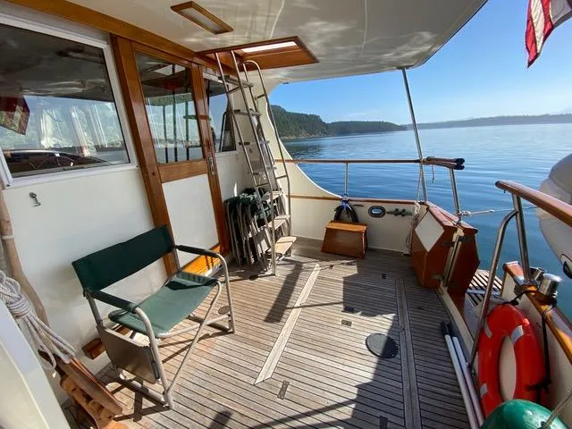  Yacht Photos Pics 1990 Grand Banks 36 Europa yacht deck with seating, ladder, and scenic water view.